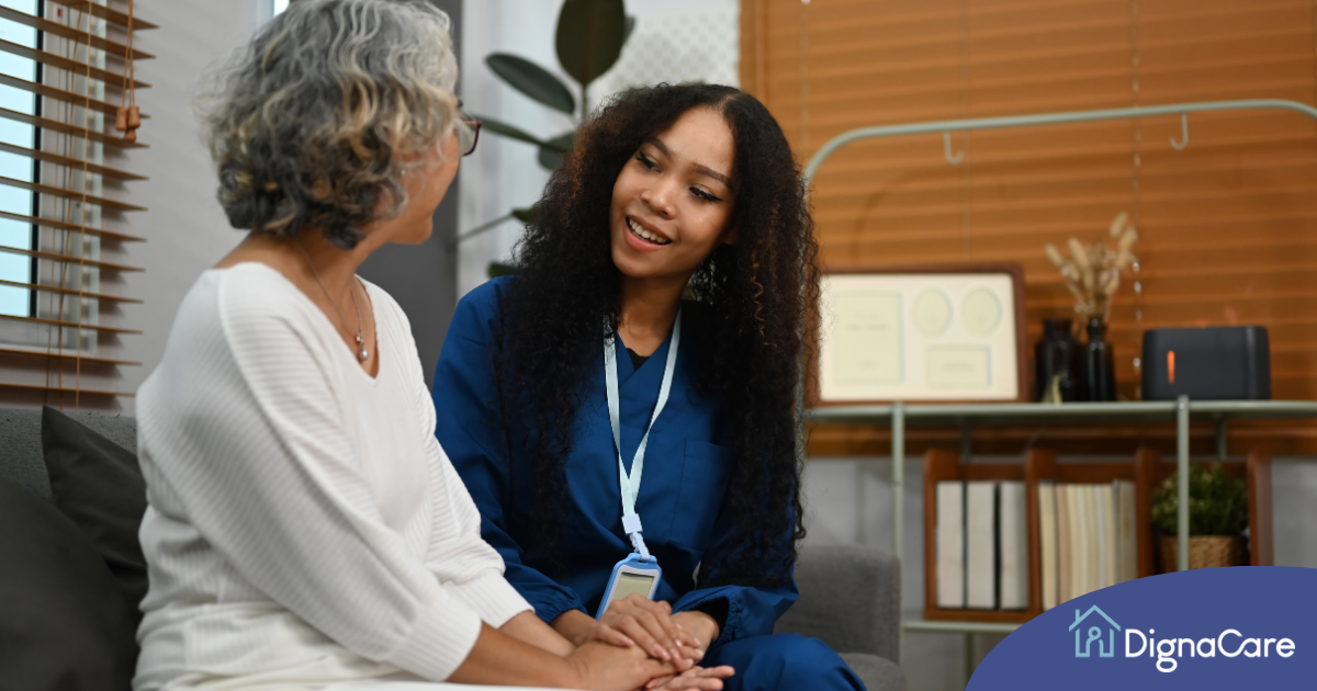 A caregiver patiently and kindly sits down and talks with a senior client, setting a good example for caregivers when it comes to communication.