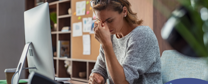 A woman is exhausted at her job as a result of struggling with balancing caregiving and her career.